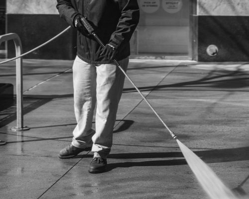 man pressure washing pavement